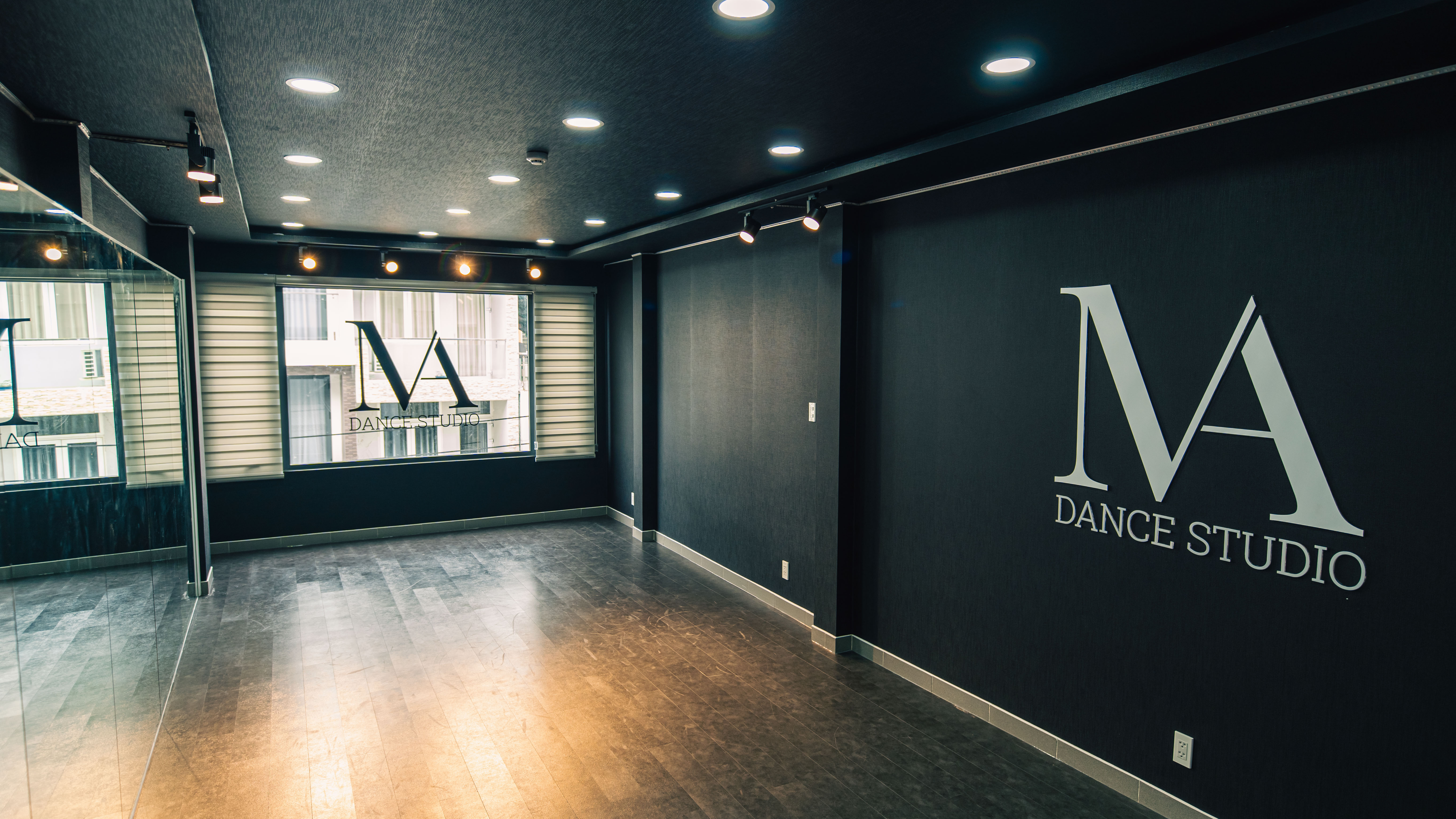 Phòng tập MA Dance Studio với tường đen, gương lớn và logo MA trên tường